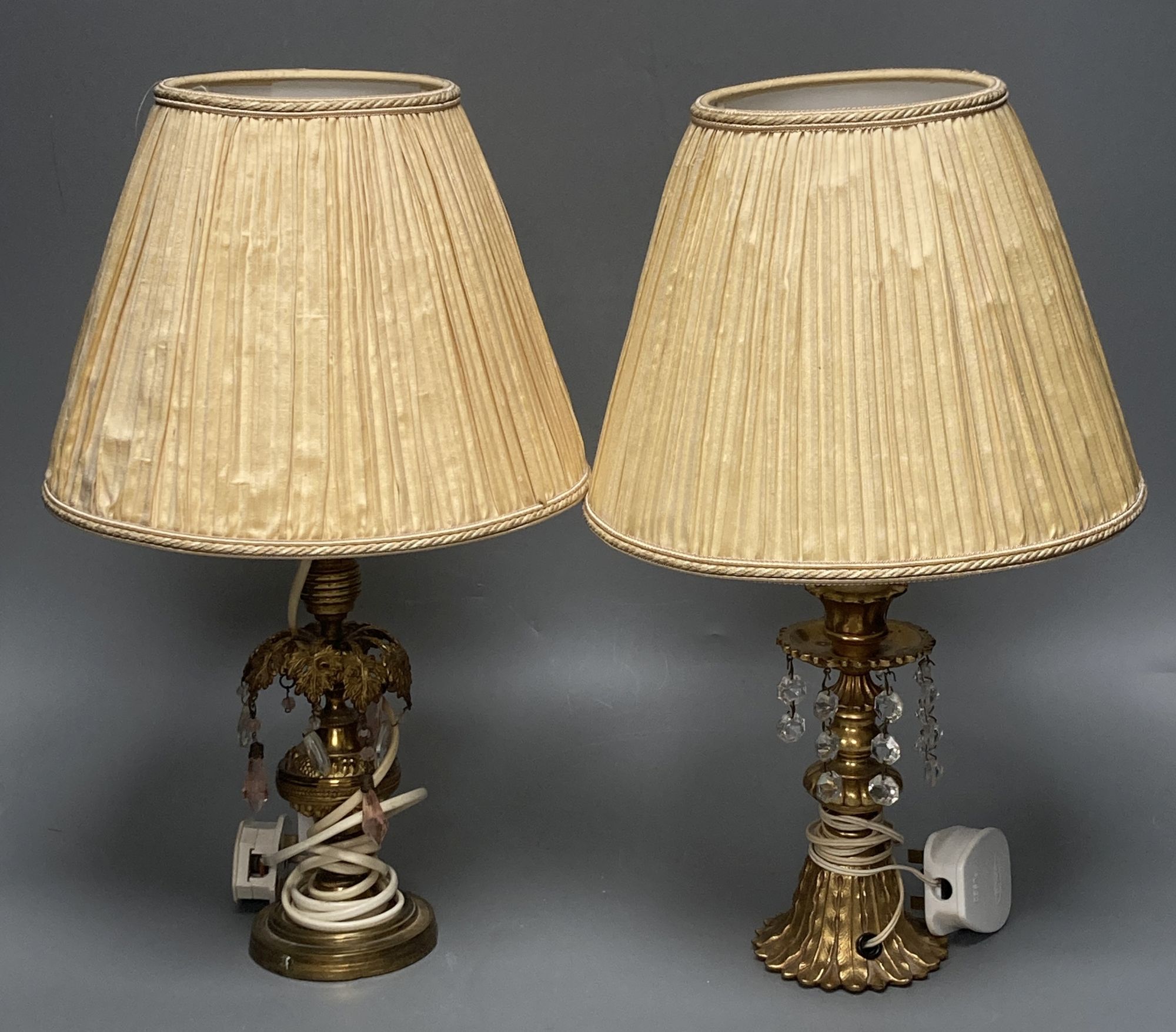A pair of gilt metal and lustre drop lamps and silk shades